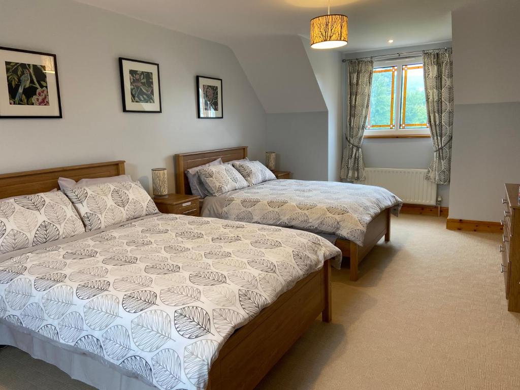 a bedroom with two beds and a window at Grangeview House in Grange
