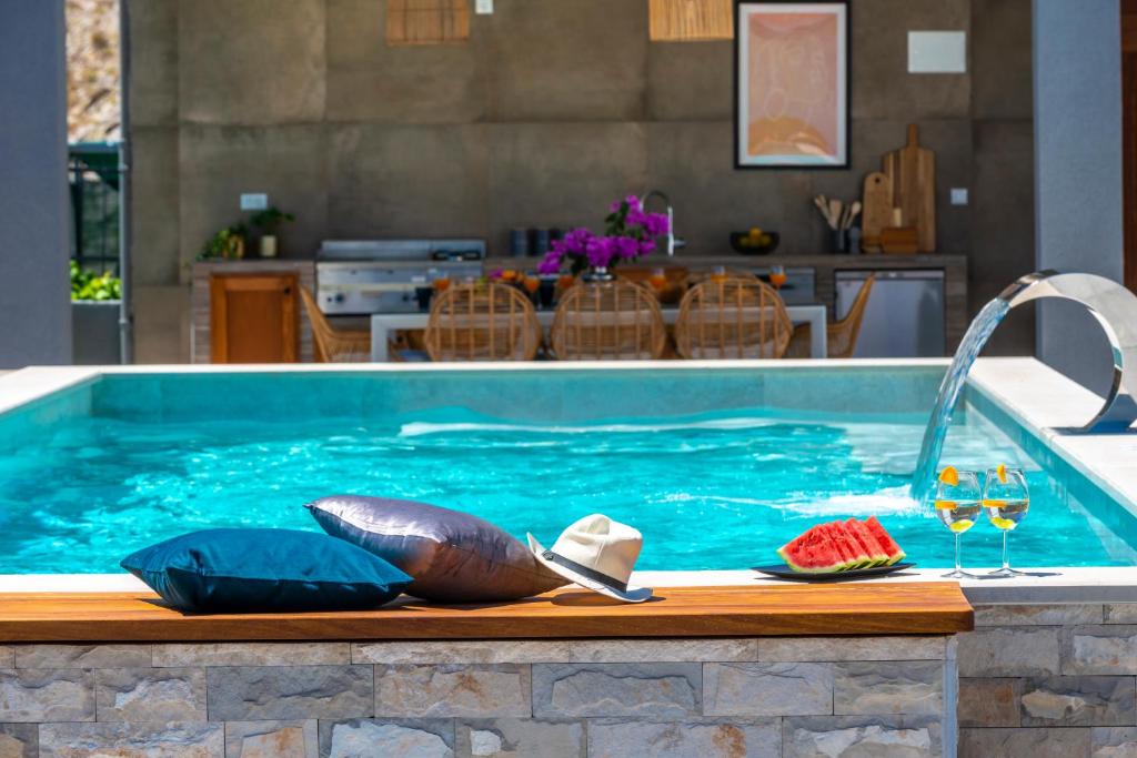 una piscina con 2 copas de vino y un tazón de agua en Villa Jelena, en Mlini