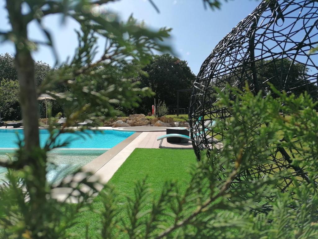 uma vista para uma piscina através de algumas árvores em PÉROLA D'ÓBIDOS t1 em Óbidos