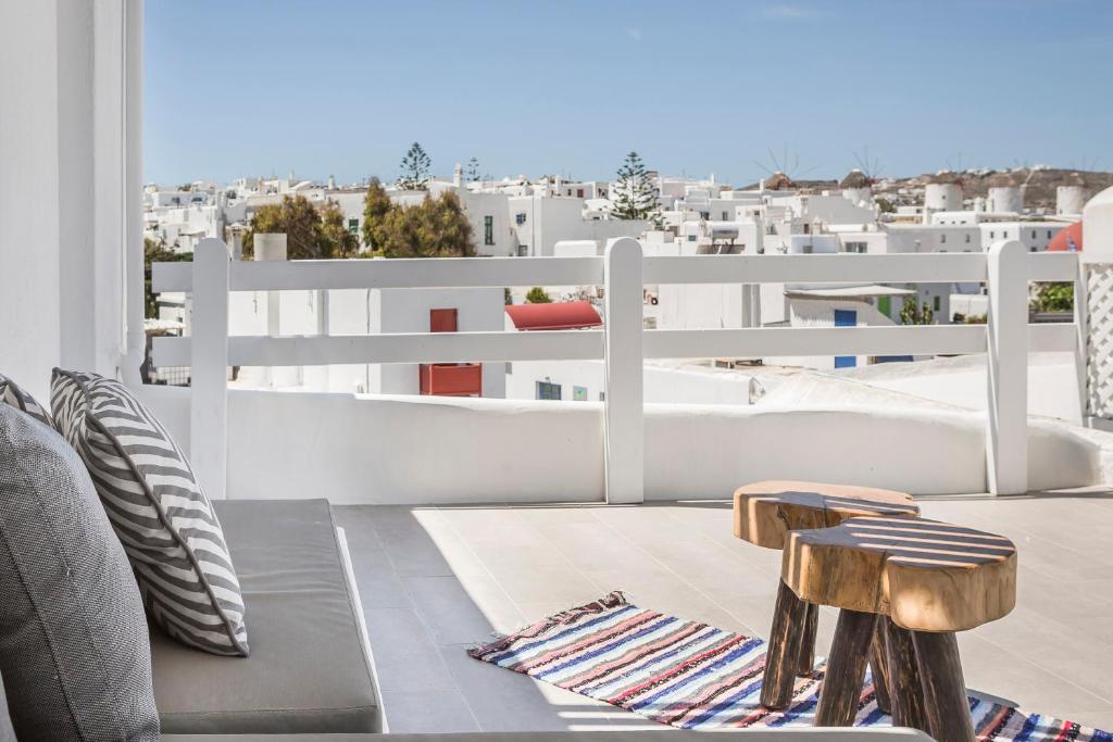 a balcony with chairs and a view of the city at Kostantis Town Suites in Mikonos