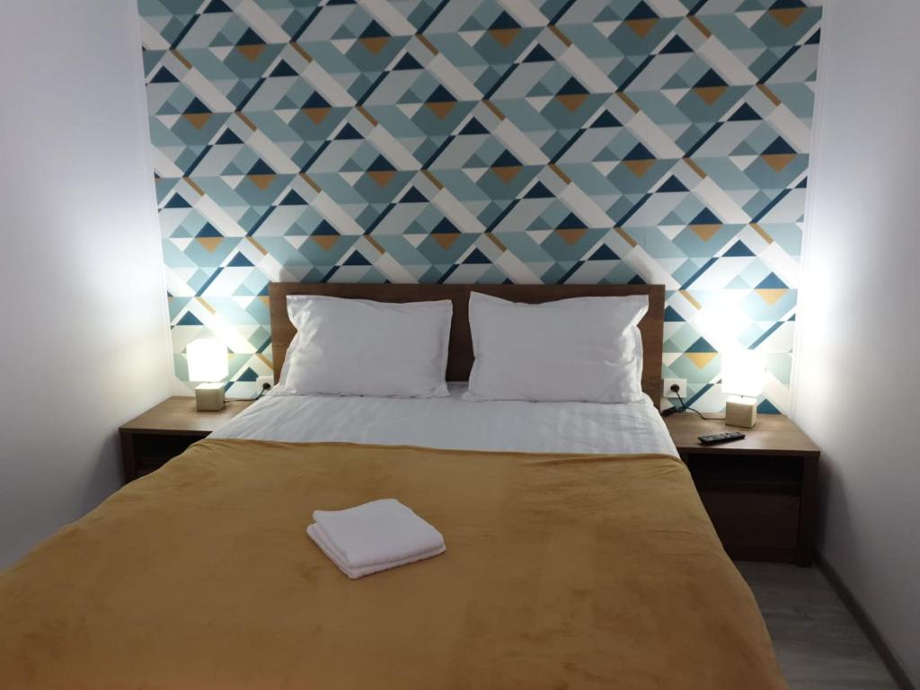 a bedroom with a large bed with a geometric wall at Alfa Relax Apartments in Saturn