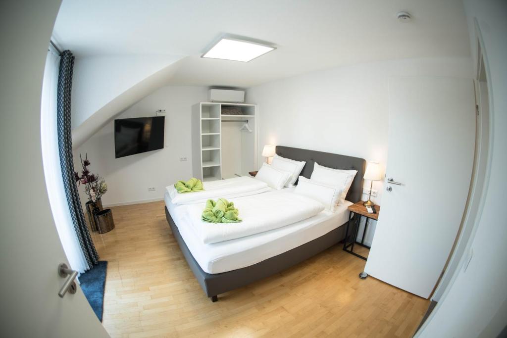 - une chambre avec un grand lit blanc et des oreillers blancs dans l'établissement City Apartments FN L8 KLIMATISIERT, à Friedrichshafen