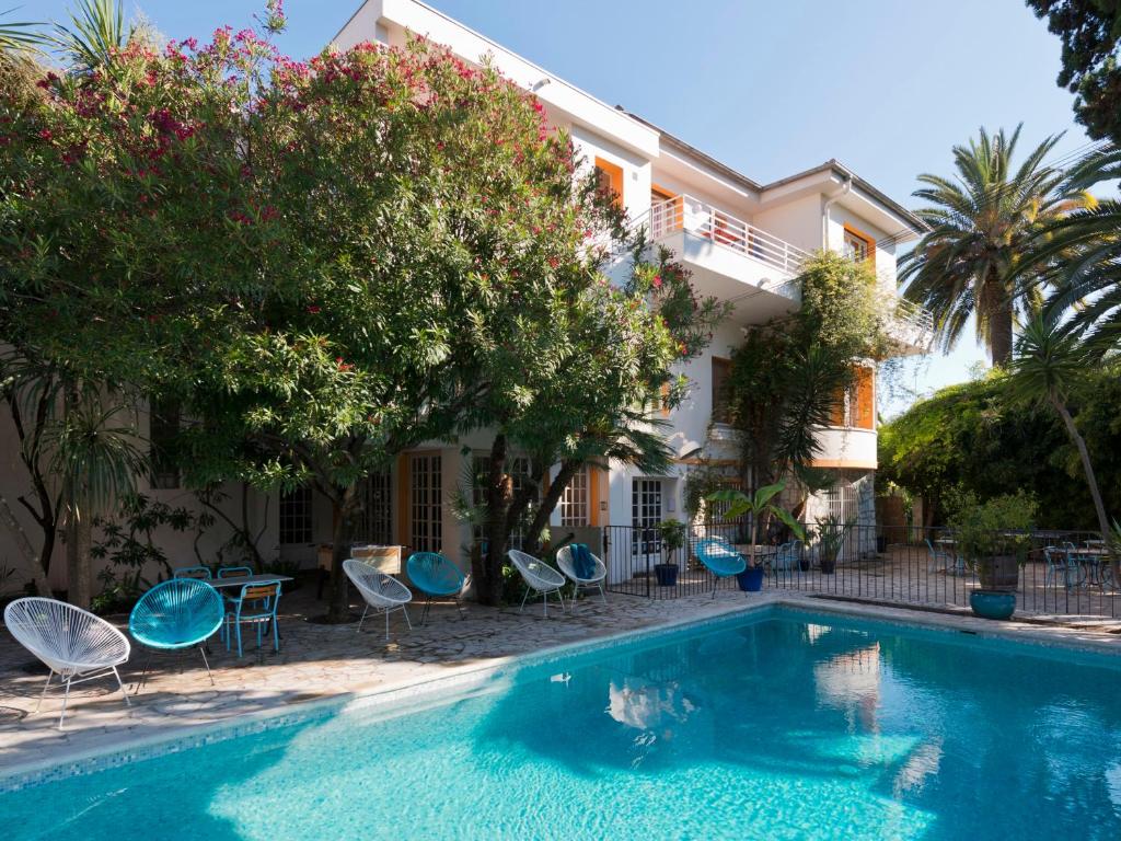 basen z krzesłami i budynek w obiekcie Le Val Duchesse Hotel & Appartements w Cagnes-sur-Mer