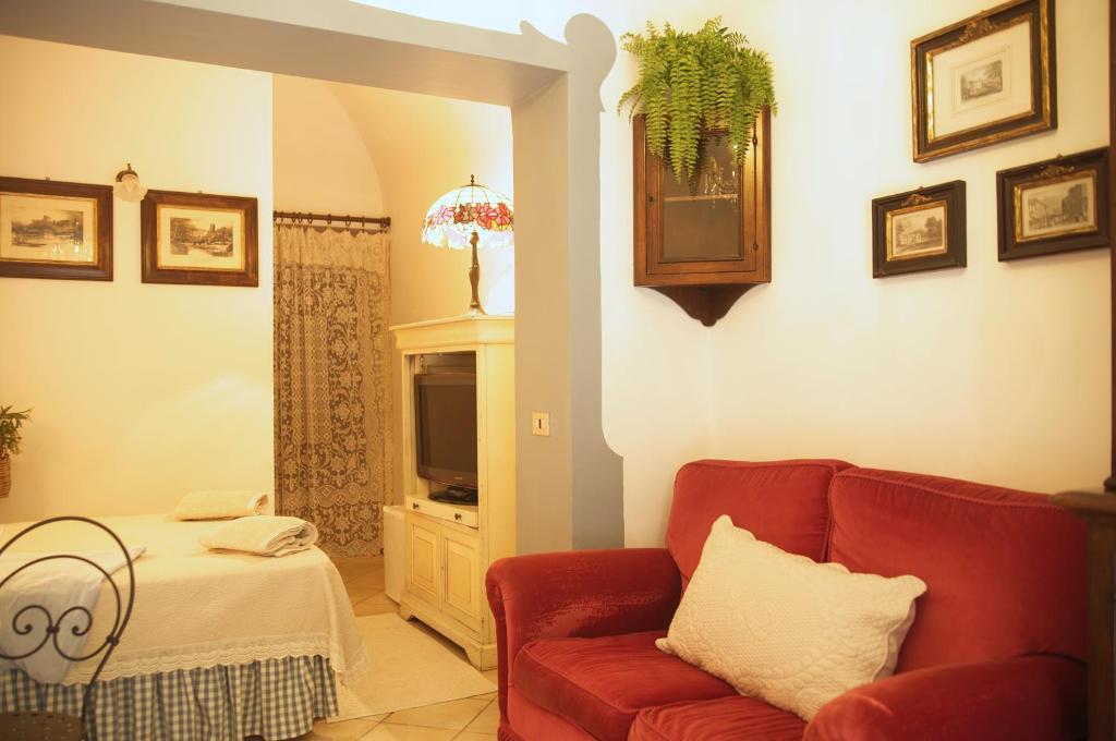 a living room with a red couch and a television at B&B del Giglio in Cefalù