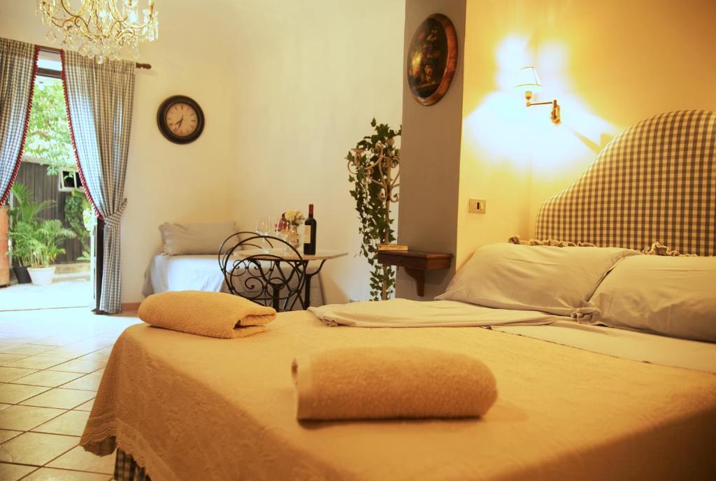 a bedroom with two beds and a clock on the wall at B&B del Giglio in Cefalù