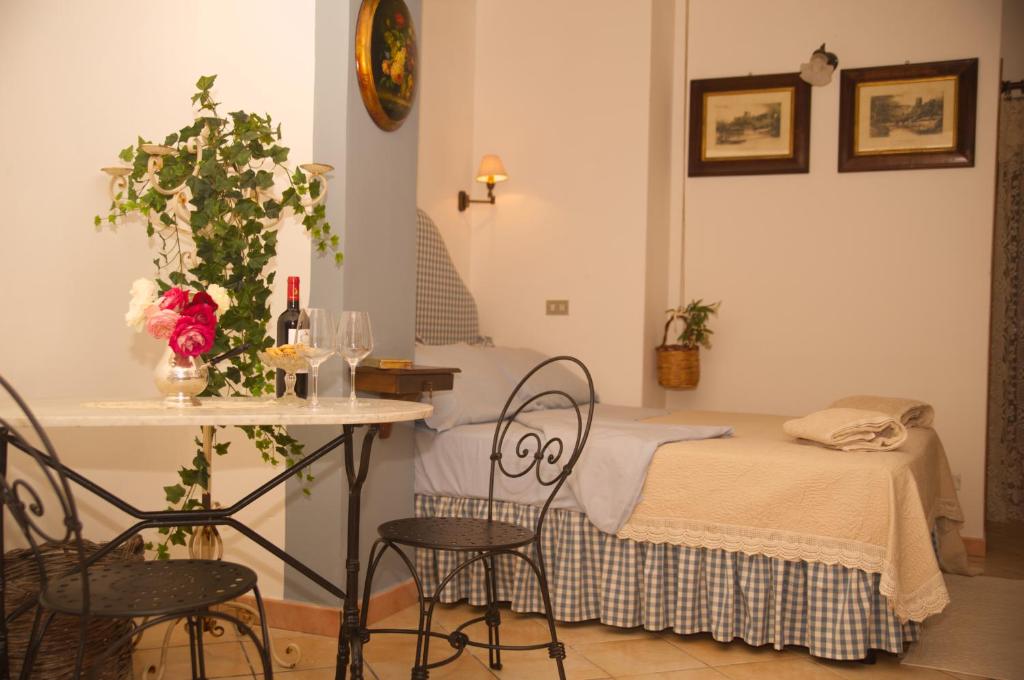 a room with a bed and a table and chairs at B&B del Giglio in Cefalù