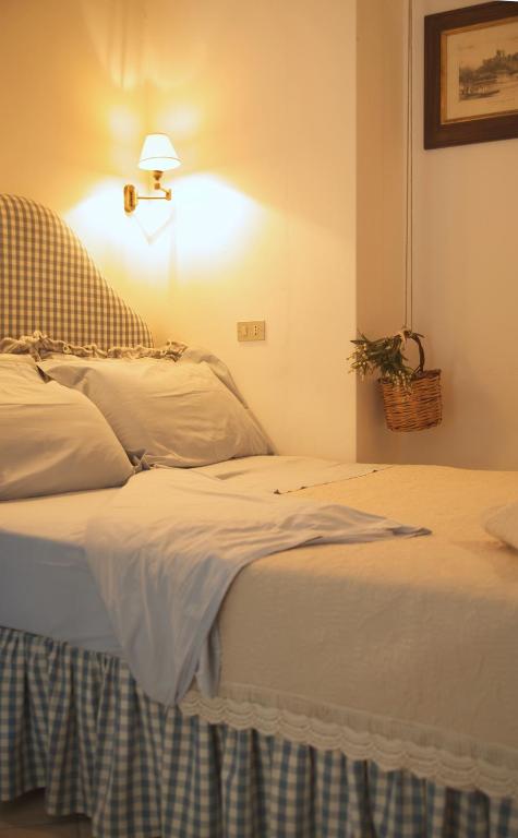 a bedroom with a bed with white sheets and a lamp at B&B del Giglio in Cefalù