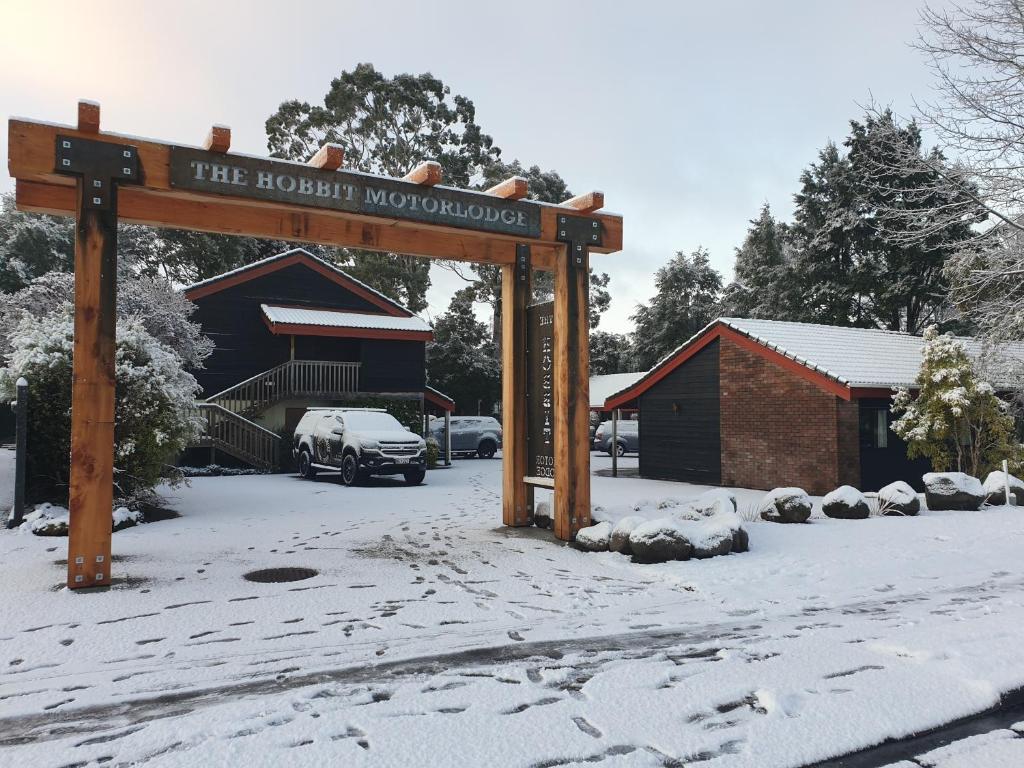 um sinal na neve em frente a um edifício em The Hobbit Motorlodge em Ohakune