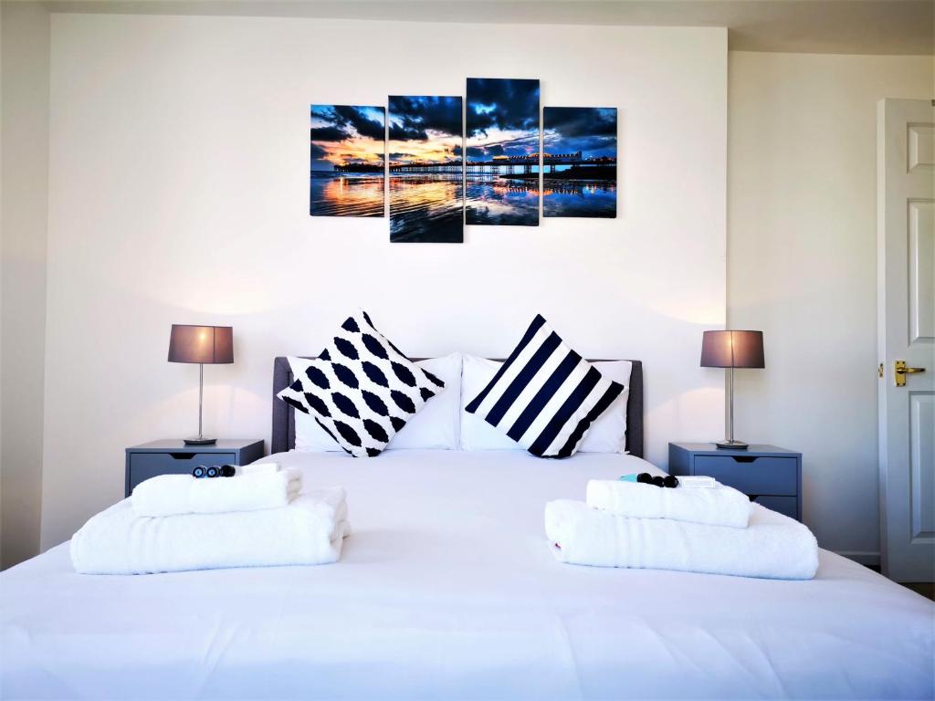 een slaapkamer met een wit bed met 2 kussens bij Marina living with parking, balcony, quiet and secure in Brighton & Hove