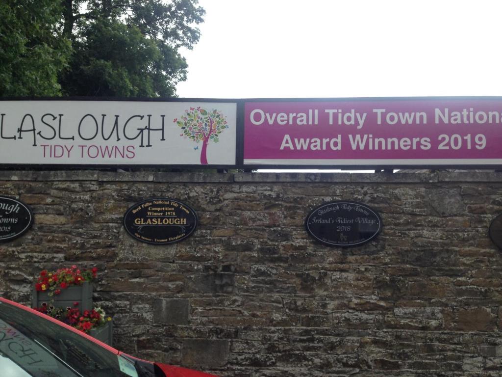 a sign on top of a brick wall at Glaslough Ramblers Rest in Monaghan