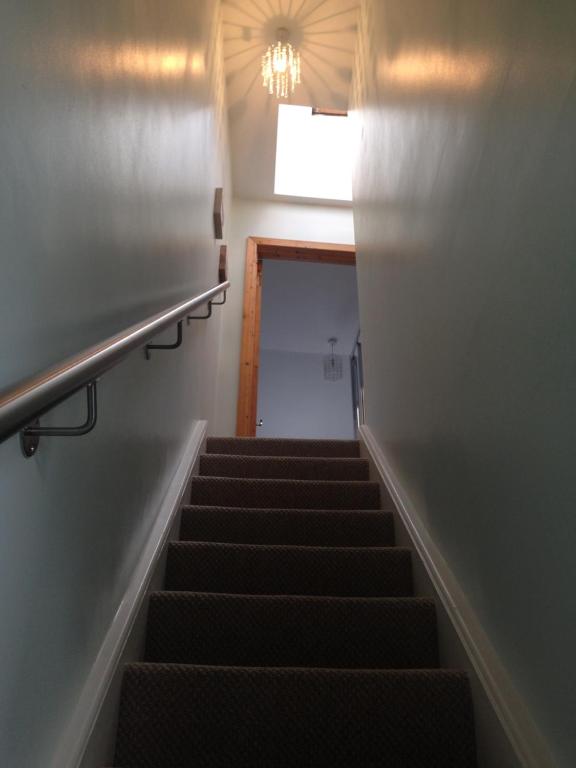 a stairway leading up to a room with a stair case at Glaslough Ramblers Rest in Monaghan
