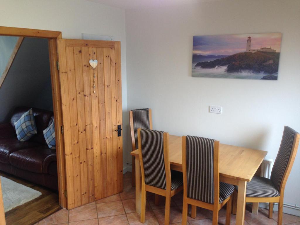 a dining room with a wooden table and chairs at Glaslough Ramblers Rest in Monaghan
