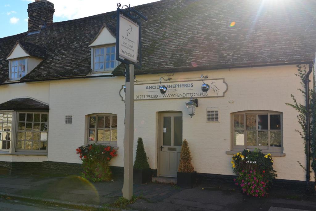 a white building with a sign in front of it at MJPatTheShepherds in Cambridge