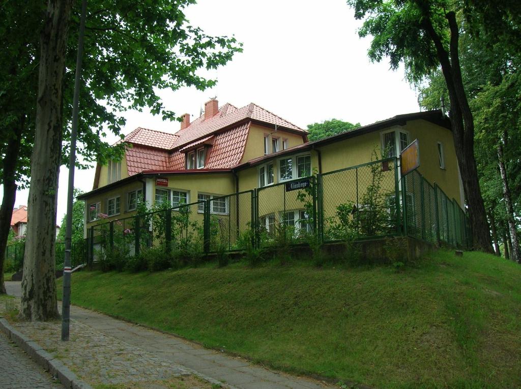 ein großes Haus mit einem Zaun davor in der Unterkunft Hotel Pod Platanami in Trzebnica