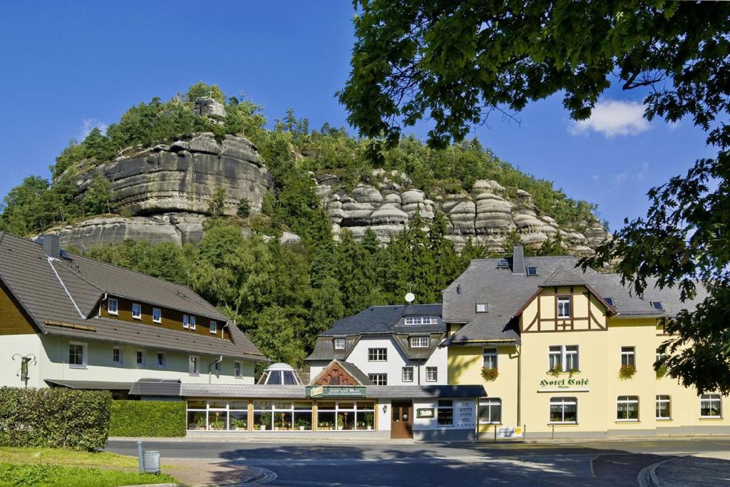 a hotel with a mountain in the background at Land-gut-Hotel Cafe Meier in Oybin