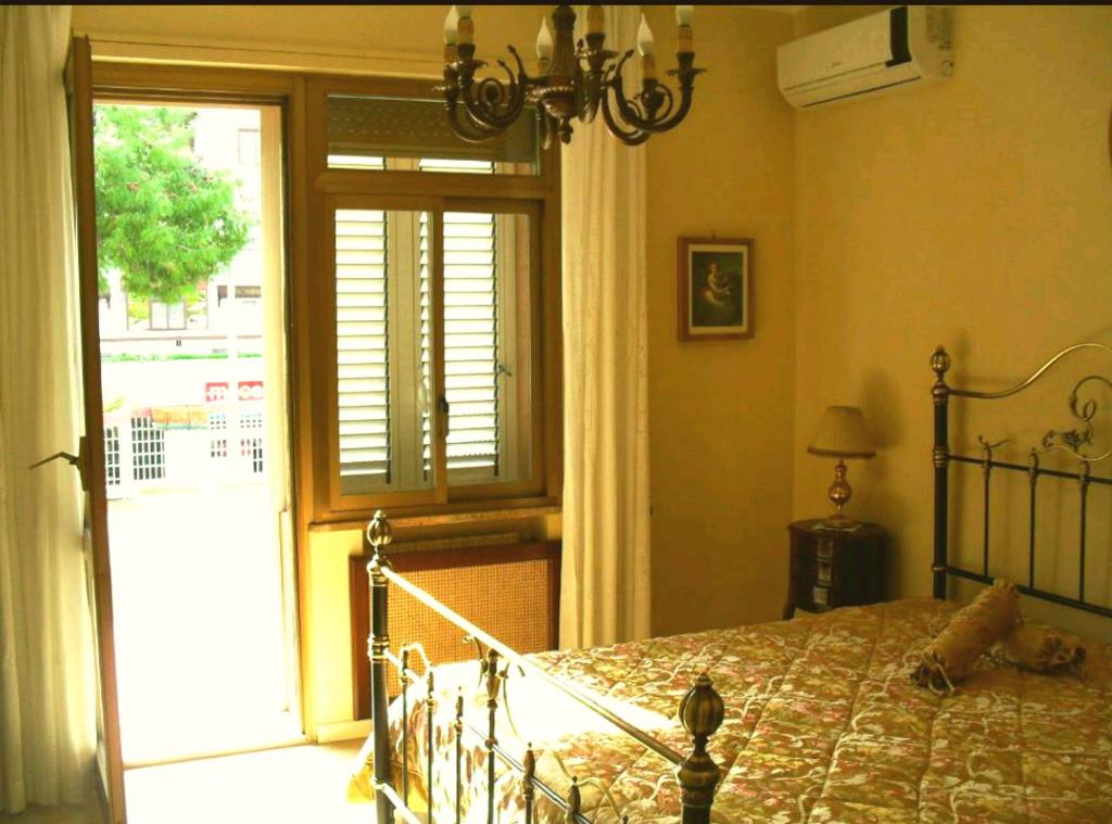 um quarto com uma cama e uma porta de vidro deslizante em I 13 Cavalieri Guest House em Barletta