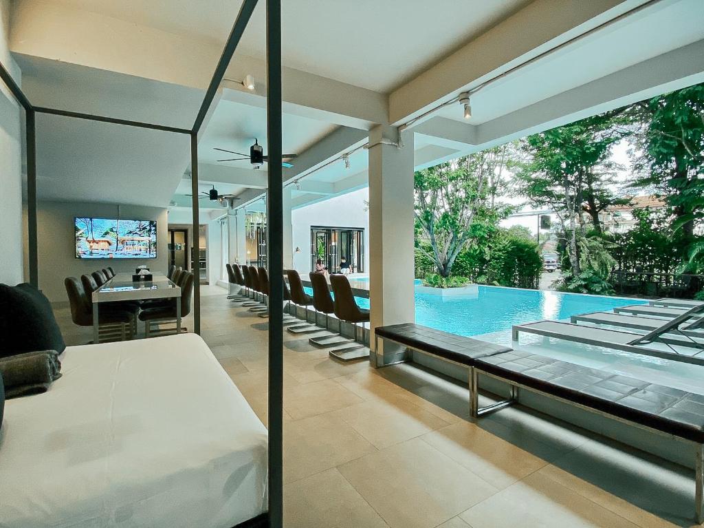 A bedroom and dining area open through glass onto a private-looking pool terrace.