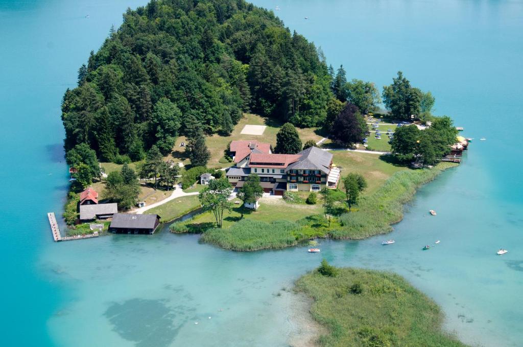 an aerial view of a house on an island in the water at Inselhotel Faakersee in Faak am See