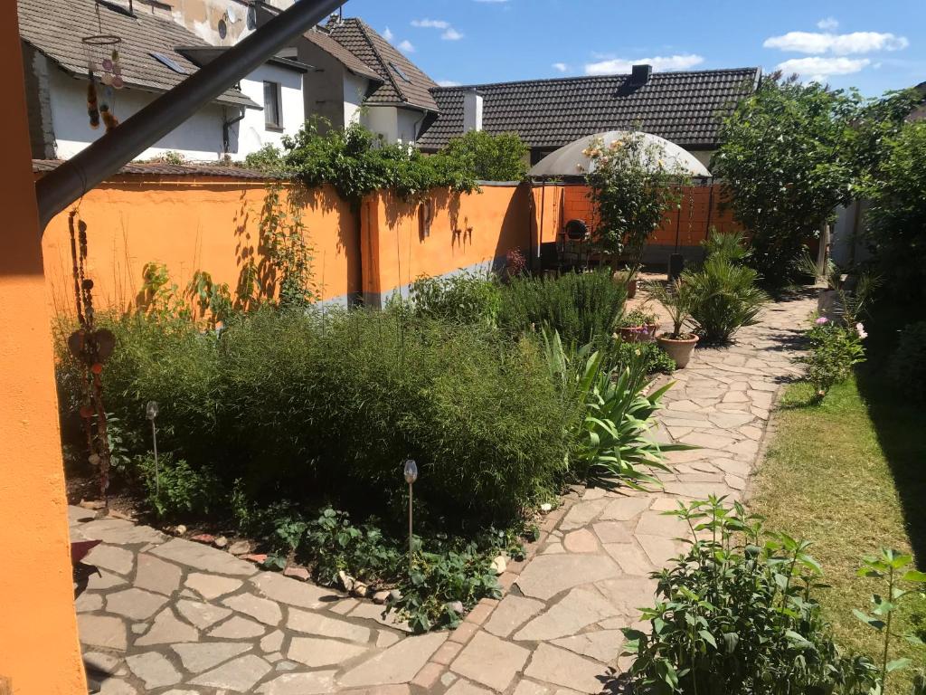 un jardin avec une clôture orange et des plantes dans l'établissement Ferienhaus Rheinperle mit Garten in Remagen am Rhein - Nähe Bonn, à Remagen