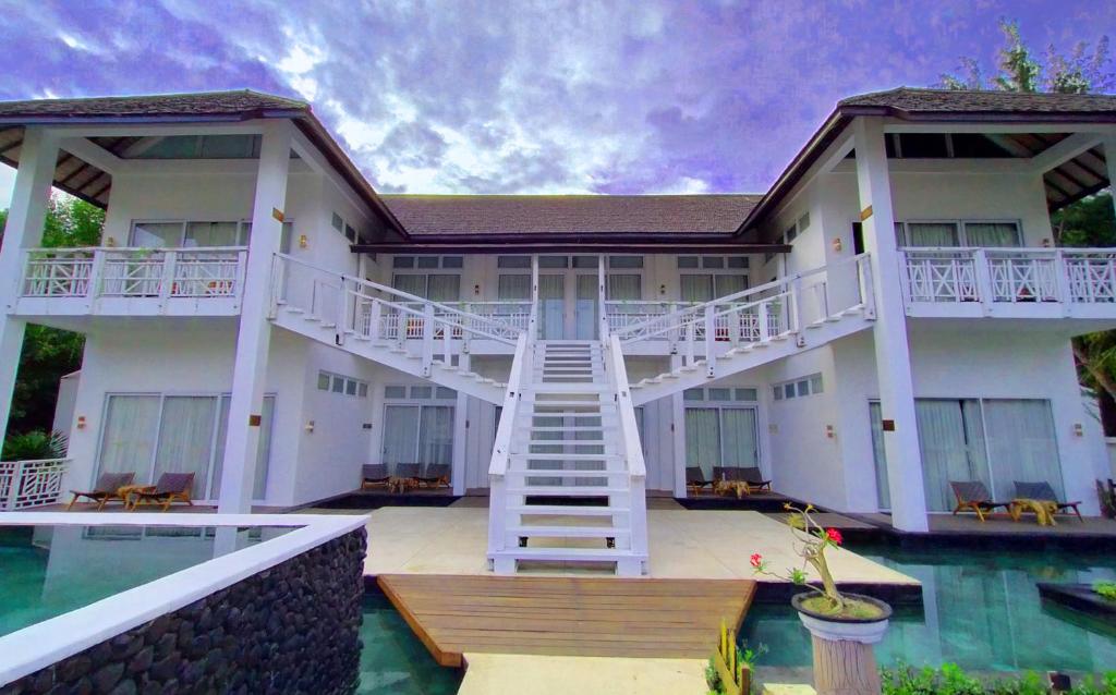 una casa con una escalera que conduce a la piscina en The Trawangan Resort, en Gili Trawangan