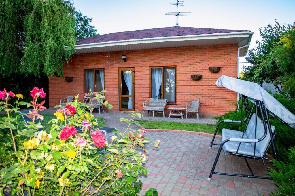 a small brick house with a chair and flowers at FONTREY in Fontanka