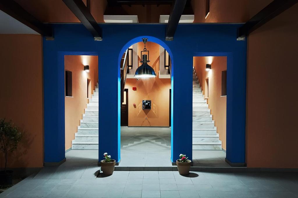 Melia Villas في إيريسوس: ممر وبه اعمدة زرقاء ودرج في مبنى