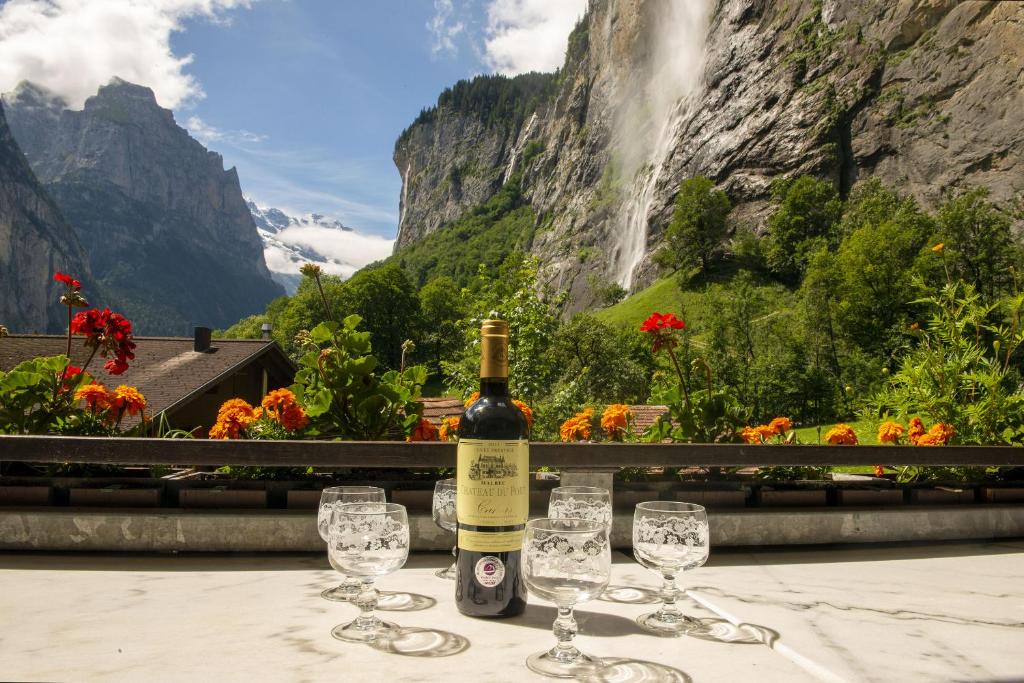 a bottle of wine sitting on a table with wine glasses at Lauterbrunnen Staubbach Beautiful Waterfall Apartment in Lauterbrunnen