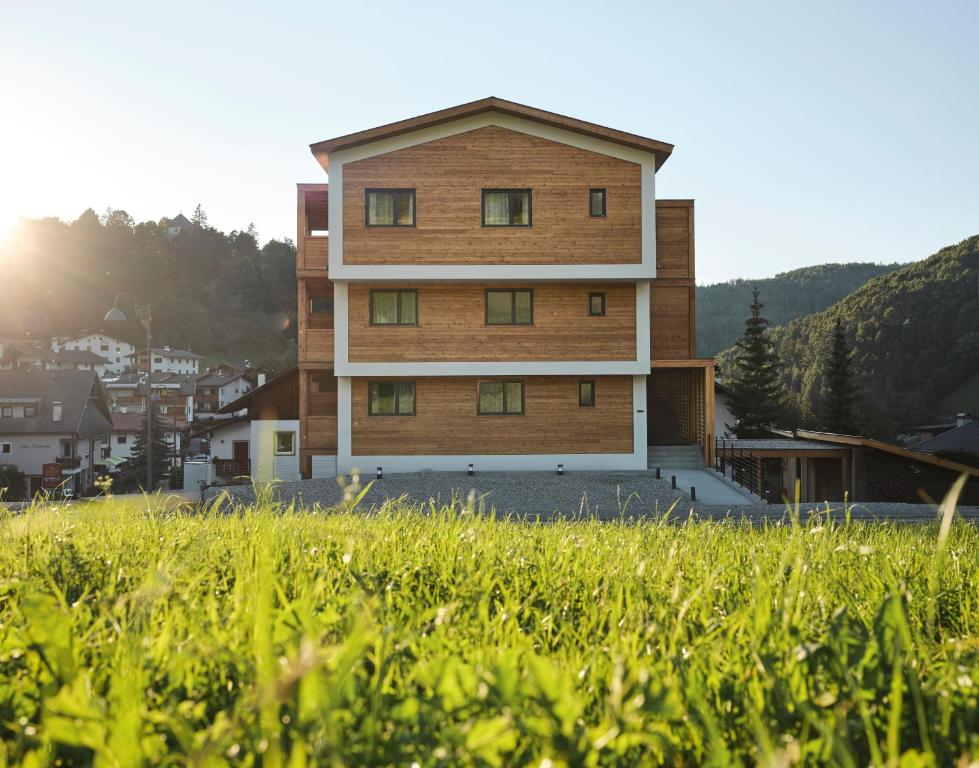 a building in the middle of a field of grass at Alpe di Susi in Castelrotto