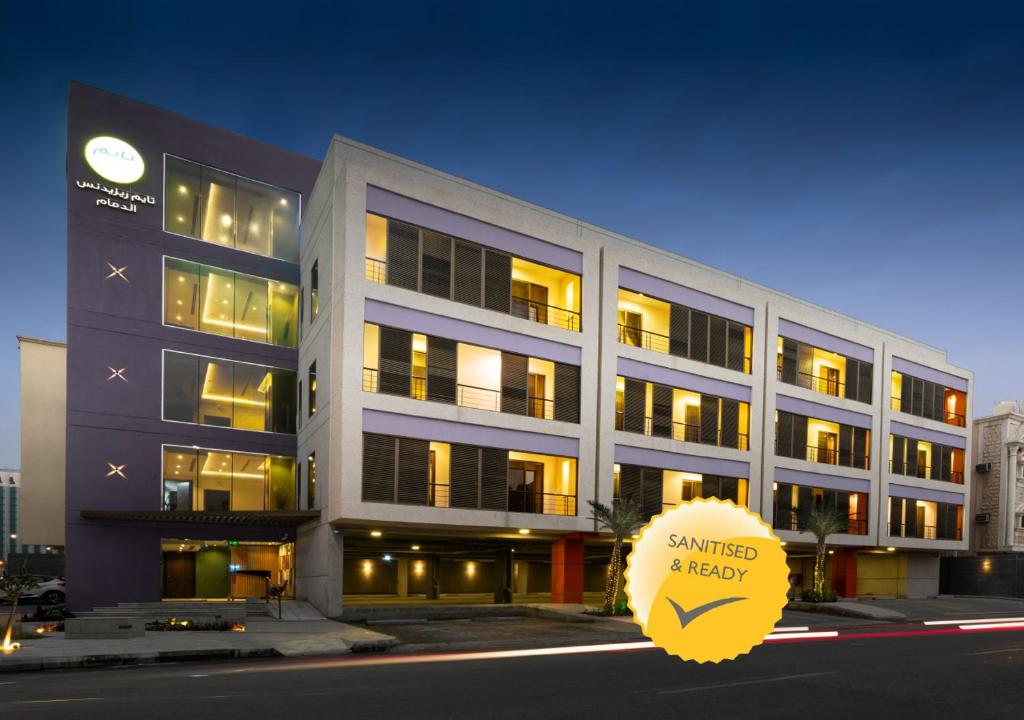 a large building with a yellow sign in front of it at TIME Dammam Residence in Dammam