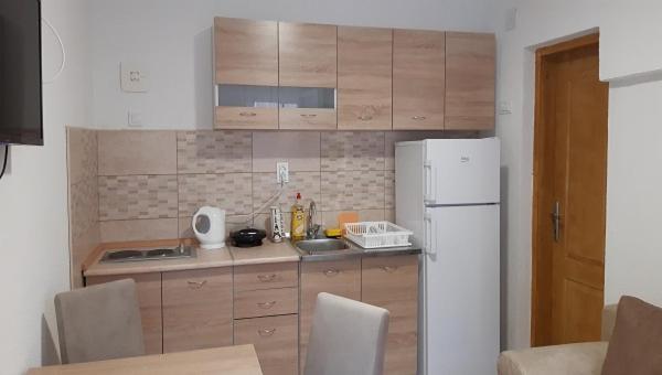 a kitchen with a white refrigerator and wooden cabinets at Apartment Sali in Kotor