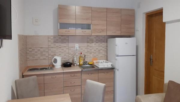kuchnia z białą lodówką i drewnianymi szafkami w obiekcie Apartment Sali w Kotorze