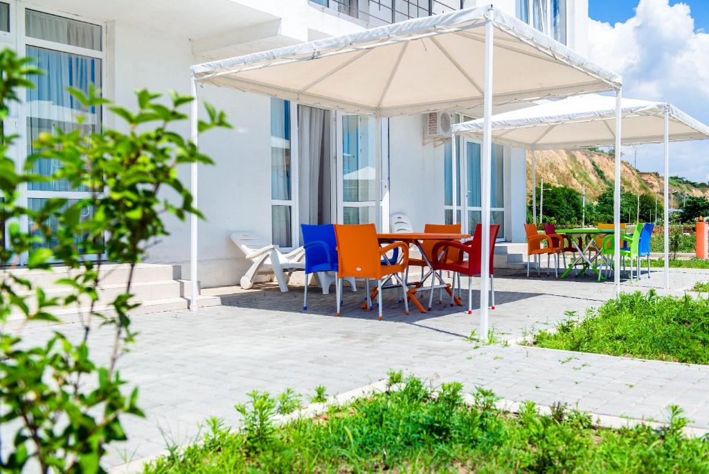 a table and chairs under an umbrella on a patio at Gold Bugaz Black Sea Hotel Group in Gribovka