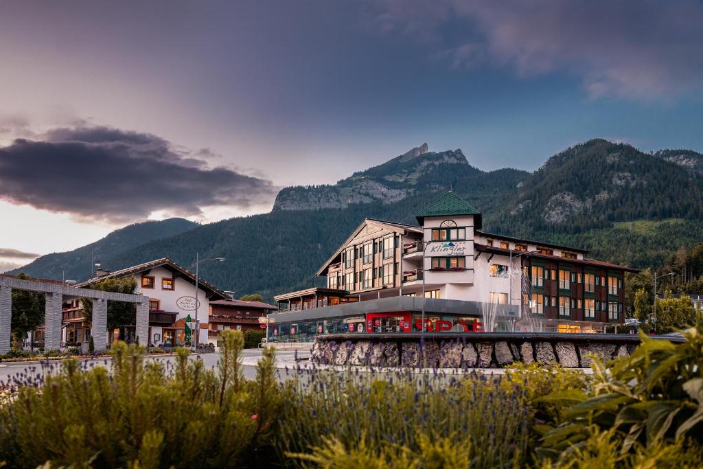 un gran edificio con montañas en el fondo en Hotel Klingler en Maurach