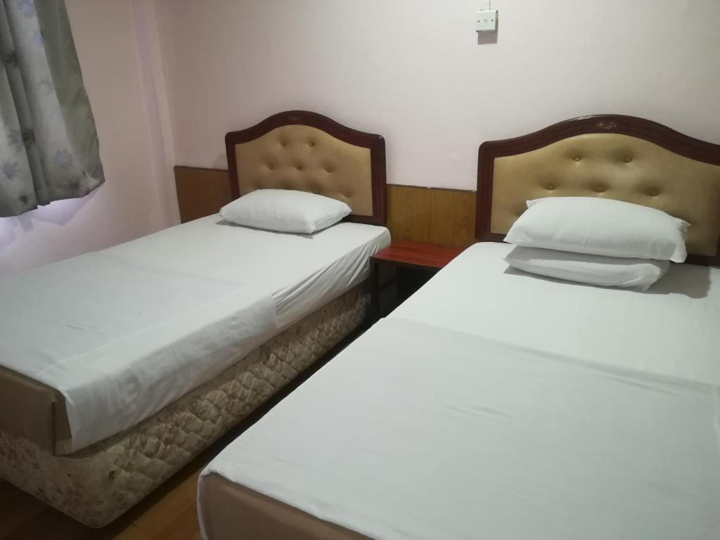 duas camas sentadas uma ao lado da outra num quarto em MIRAMAR HOTEL em Sibu