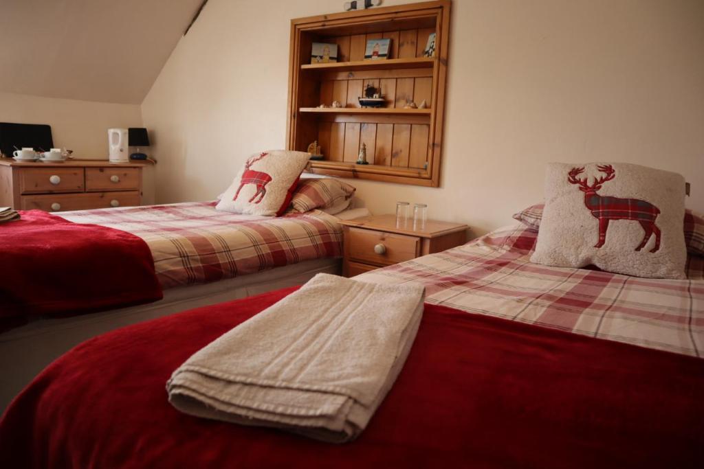 a bedroom with two beds with red sheets at The White Hart Inn in Tetford