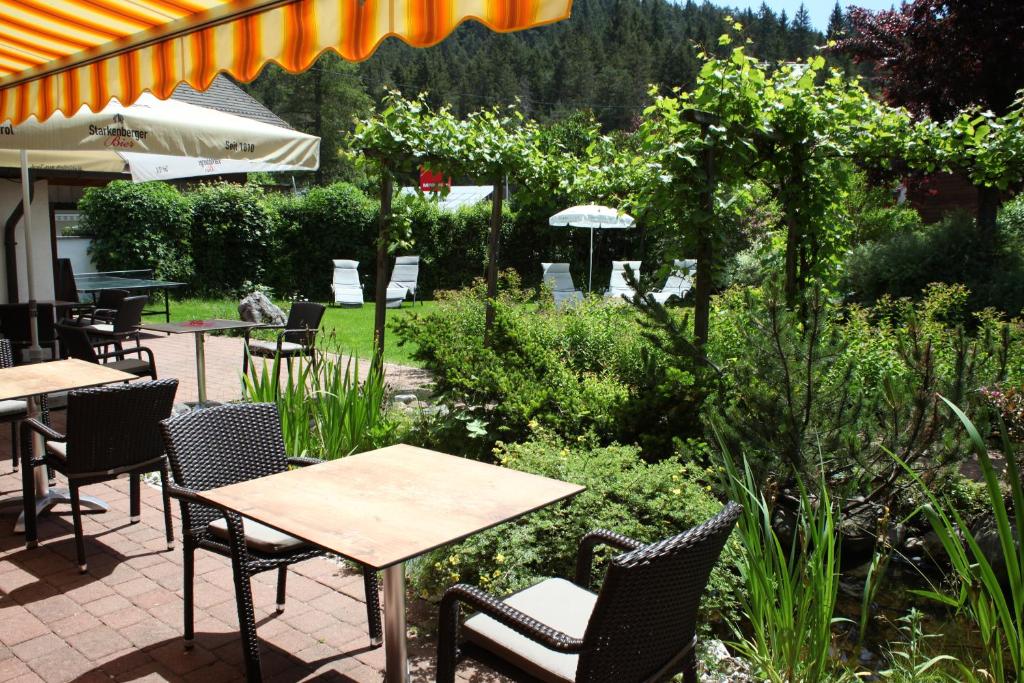 un patio con mesas y sillas en un jardín en Bergfrieden Leutasch/Seefeld en Leutasch