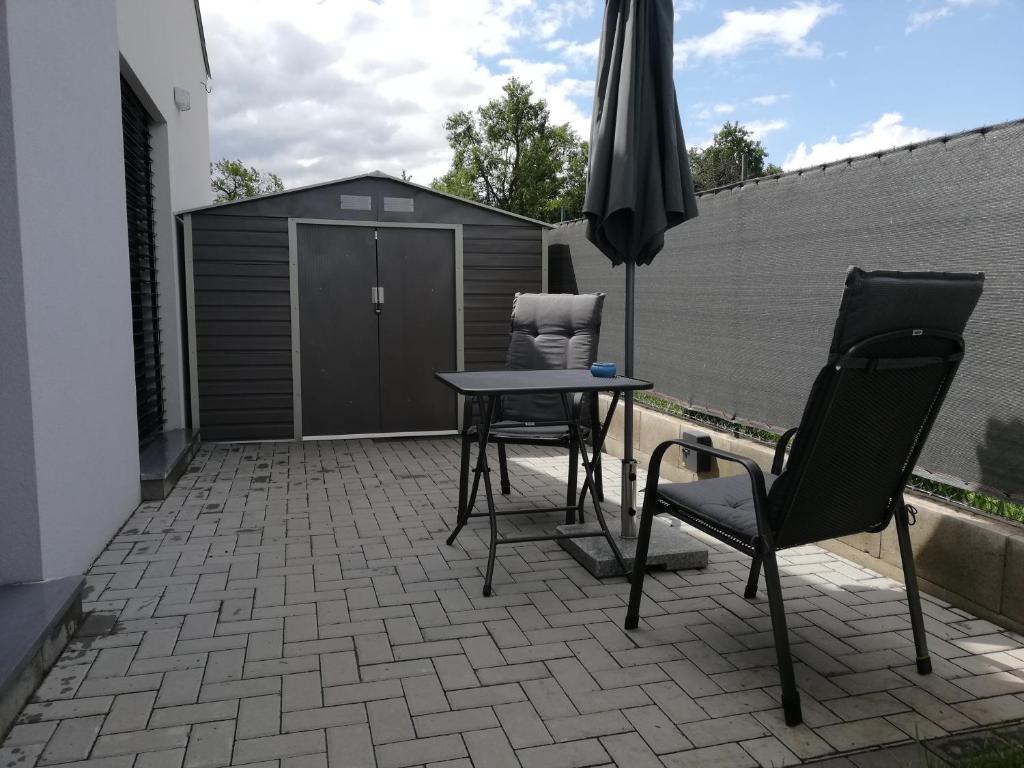 patio ze stołem, 2 krzesłami i parasolem w obiekcie Apartmán Bezkov 108 w mieście Bezkov