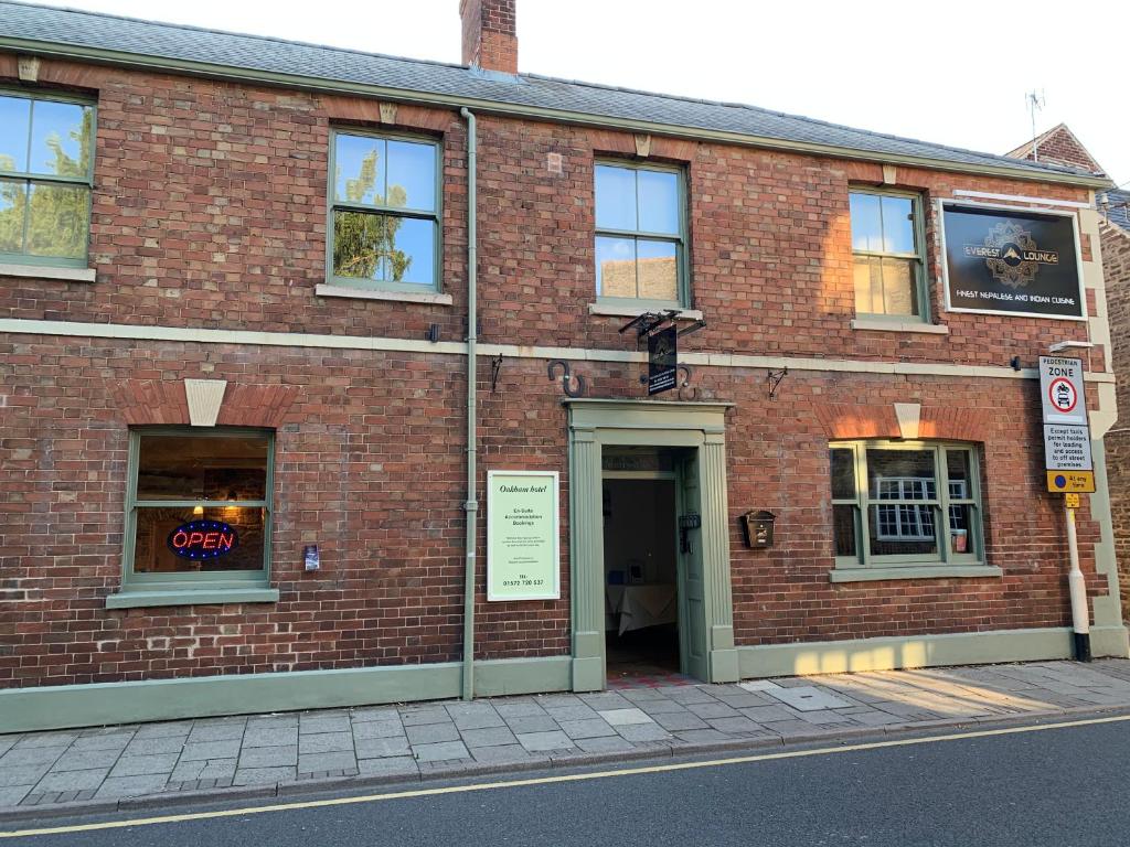 a brick building with a door on a street at Oakham Hotel in Oakham