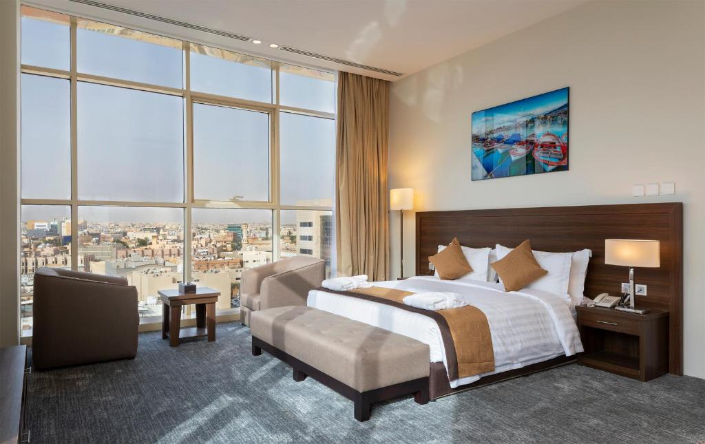 Seiba Hotel Apartments-Riyadh في الرياض: غرفة نوم بسرير كبير ونافذة كبيرة
