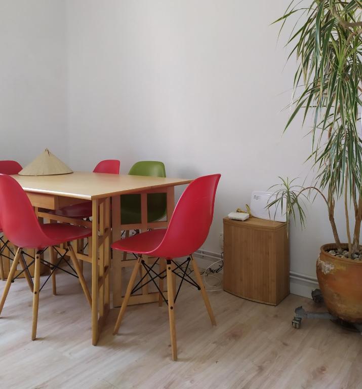 a table with red chairs in a room with a plant at Living Pontevedra in Pontevedra