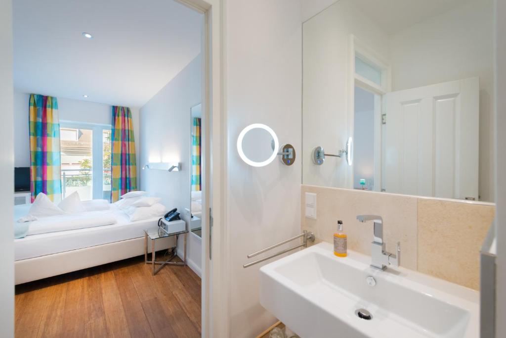 a bathroom with a bed and a sink and a mirror at 35qm Deluxe Apartment Suites im Stil Design Hotel Vosteen Nähe der Kaiserburg in Nuremberg