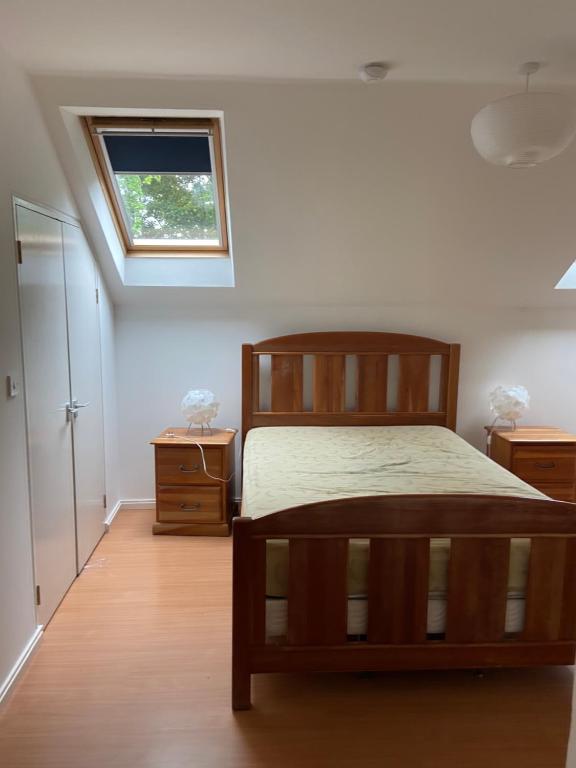a bedroom with a wooden bed and a window at The Loft in Kilmessan
