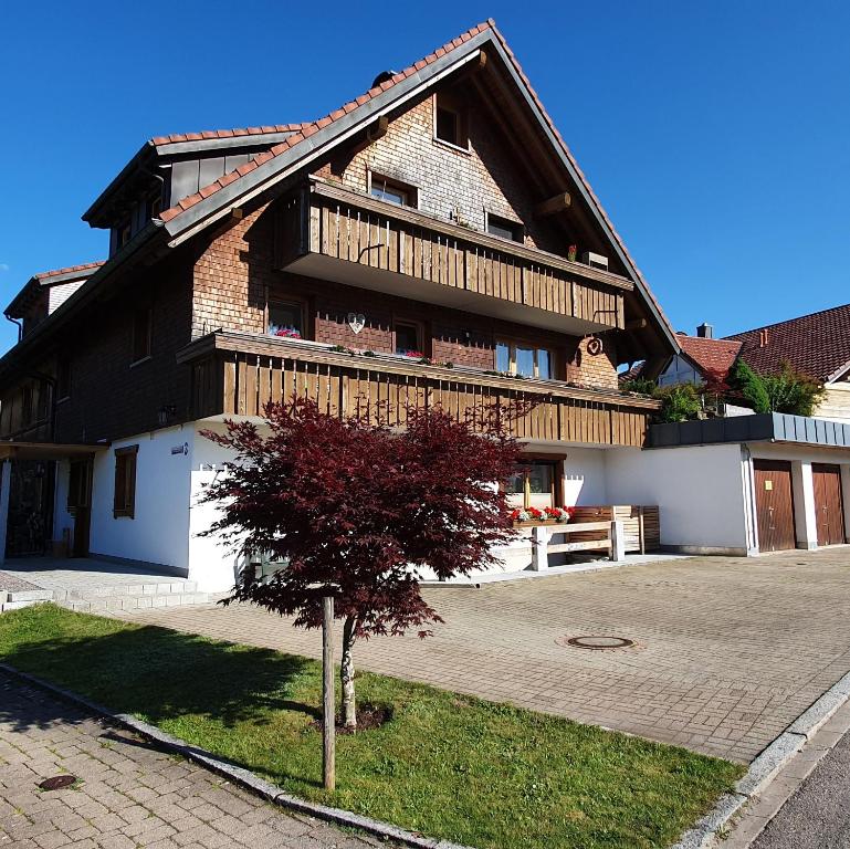 a house with a tree in front of it at Ferienwohnung Hitz in Hinterzarten