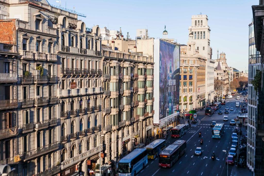 a view of a city street with buses and buildings at Be Barcelona Plaza Catalunya in Barcelona