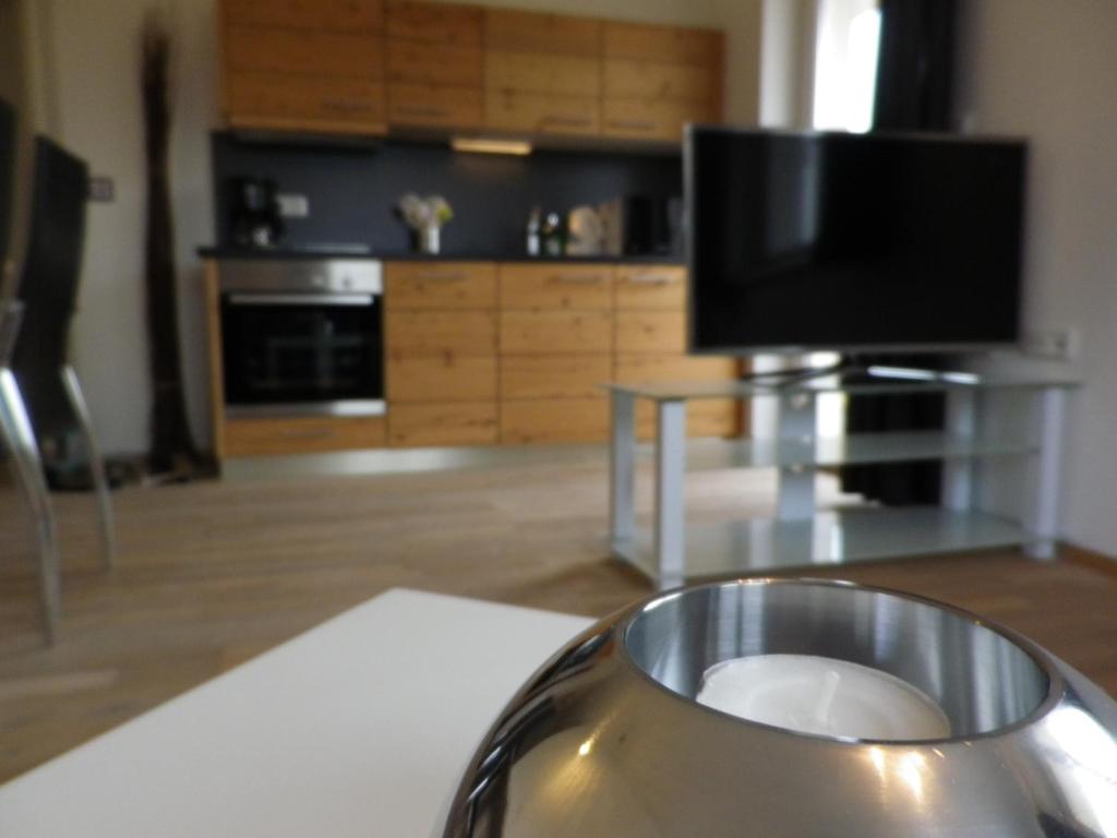 a living room with a television and a table with a vase at Haus 4 Holidays in Bramberg am Wildkogel