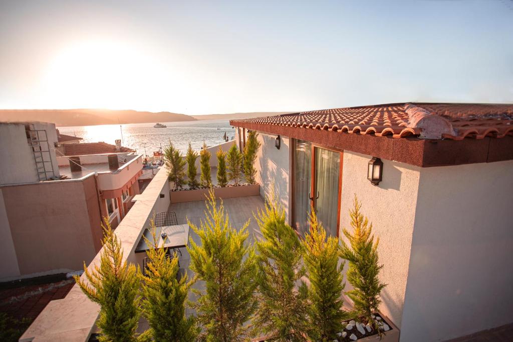 a building with a view of the ocean and a house at Hotel Kale 17 in Çanakkale