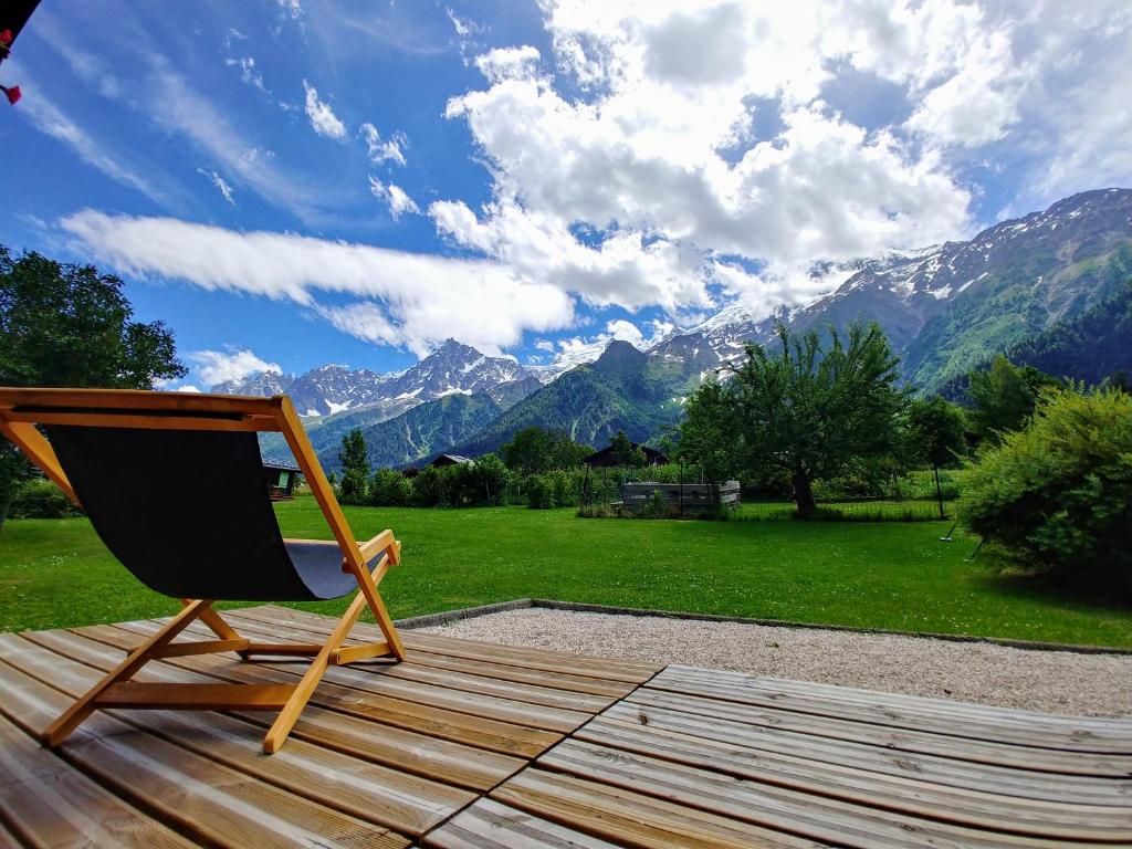 a chair on a deck with a view of mountains at Chalet Le Marmouzet in Les Houches