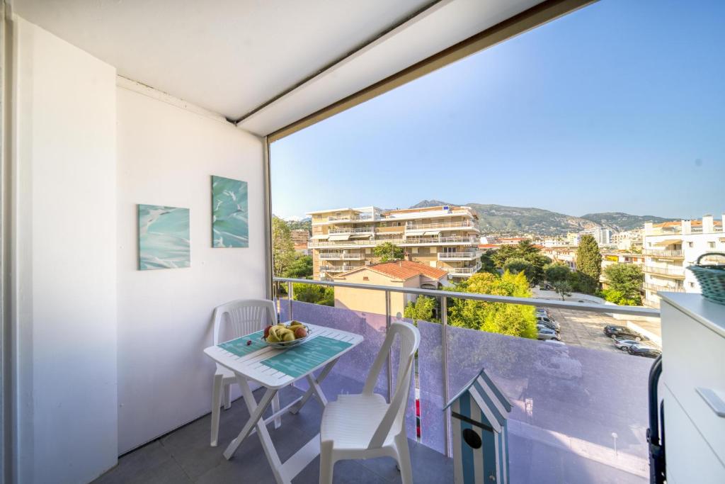 a small table and chairs on a balcony with a view at Blue Beach in Roquebrune-Cap-Martin