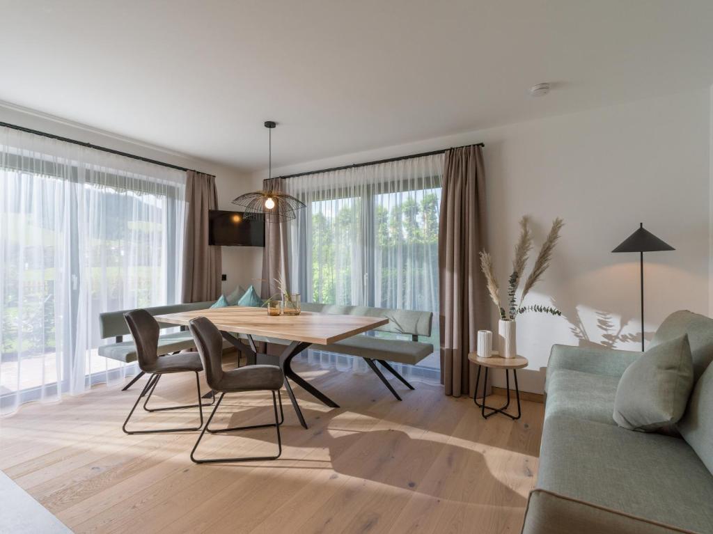 uma sala de estar com uma mesa e cadeiras e um sofá em Appartements Retthäusl em Going