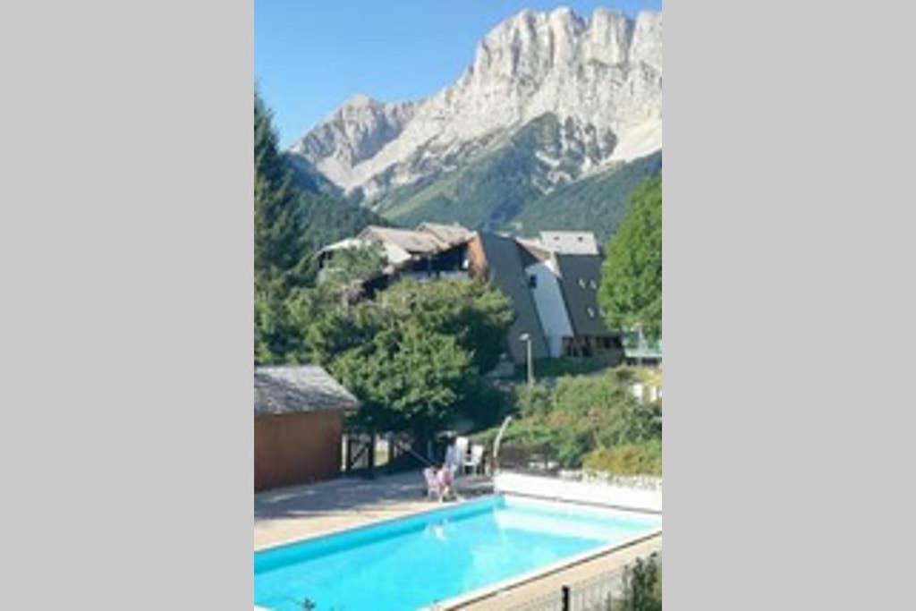 ein Schwimmbad mit einem Berg im Hintergrund in der Unterkunft Studio mansardé 18 m2 climatisé avec piscine privée in Gresse-en-Vercors